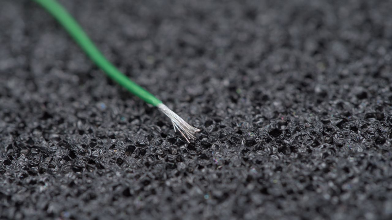Several wires that together form a conductor, with green ETFE insulation around it.